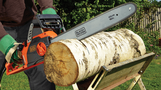 A Black+Decker chainsaw cutting wood A Black+Decker chainsaw cutting wood