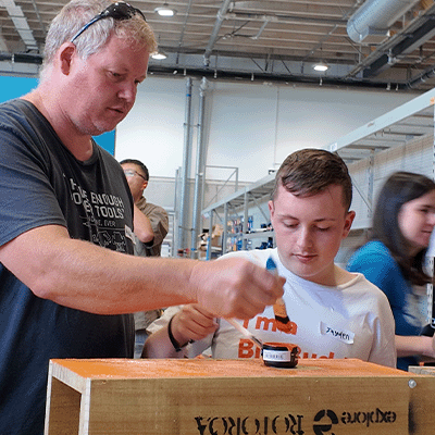 Big and Little Buddy building a rat trap at a Mitre 10 workshop.