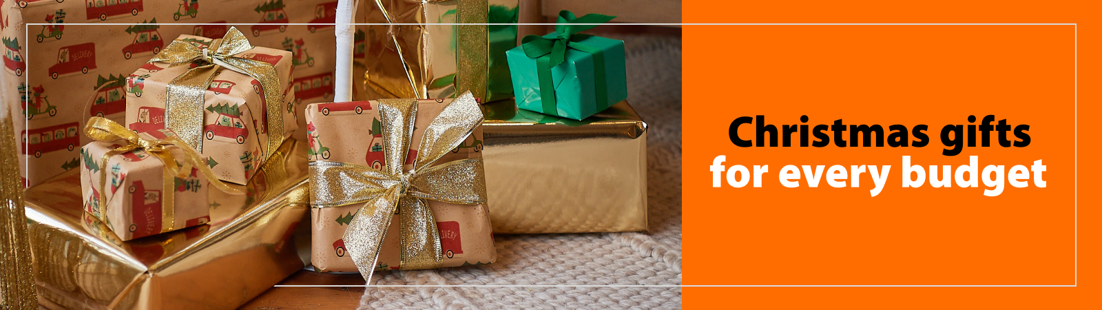 A customer and Mitre 10 staff member walk through a Mitre 10 store carrying wrapping paper and a trolley full of product. Accompanied by a heading "Loads of Christmas gift ideas to suit your budget"
